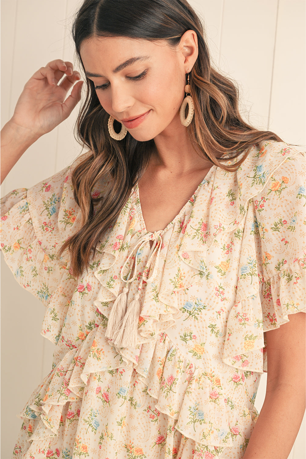 Embrace boho vibes with this apricot mini dress featuring a floral print and ruffle details. The tassel tie neckline adds a playful touch, perfect for summer days or relaxed evenings. A flattering V-neckline and flowing silhouette combine comfort and style effortlessly. The soft apricot hue pairs beautifully with the floral pattern for a feminine look.