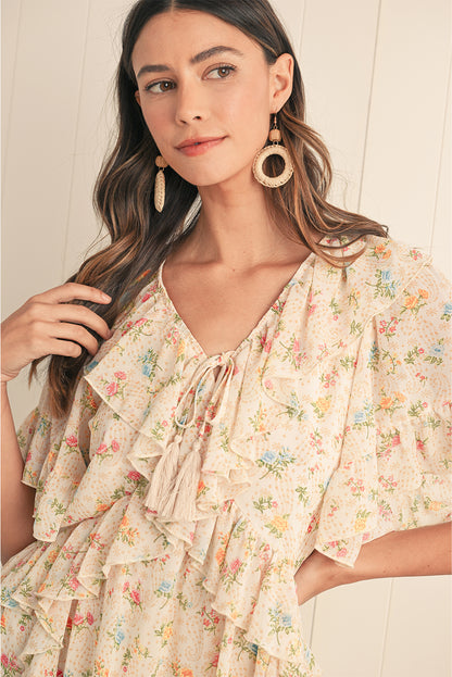 Embrace boho vibes with this apricot mini dress featuring a floral print and ruffle details. The tassel tie neckline adds a playful touch, perfect for summer days or relaxed evenings. A flattering V-neckline and flowing silhouette combine comfort and style effortlessly. The soft apricot hue pairs beautifully with the floral pattern for a feminine look.