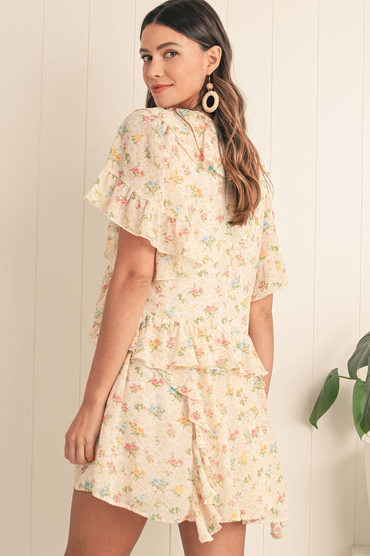 Embrace boho vibes with this apricot mini dress featuring a floral print and ruffle details. The tassel tie neckline adds a playful touch, perfect for summer days or relaxed evenings. A flattering V-neckline and flowing silhouette combine comfort and style effortlessly. The soft apricot hue pairs beautifully with the floral pattern for a feminine look.