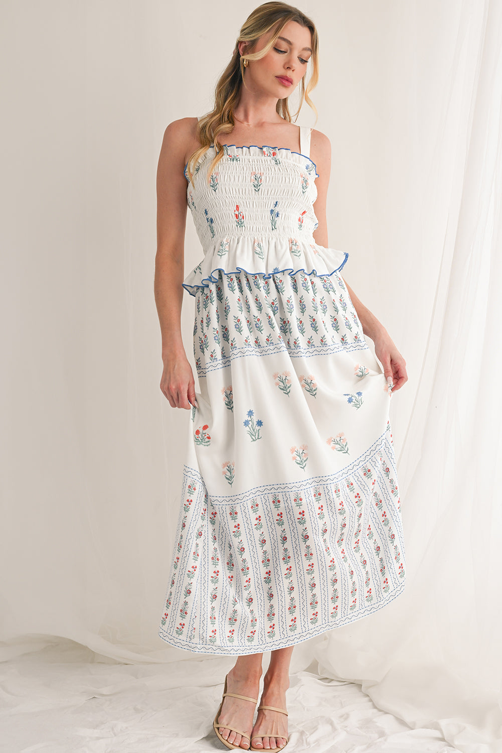 White Floral Print Boho Dress with elegant frill details for a stylish, feminine look. Smocked bodice ensures a flattering fit and all-day comfort. Flowing ruffle hem adds a romantic, bohemian touch. Fresh floral print on white, perfect for spring, summer, or casual occasions.