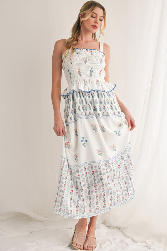 White Floral Print Boho Dress with elegant frill details for a stylish, feminine look. Smocked bodice ensures a flattering fit and all-day comfort. Flowing ruffle hem adds a romantic, bohemian touch. Fresh floral print on white, perfect for spring, summer, or casual occasions.